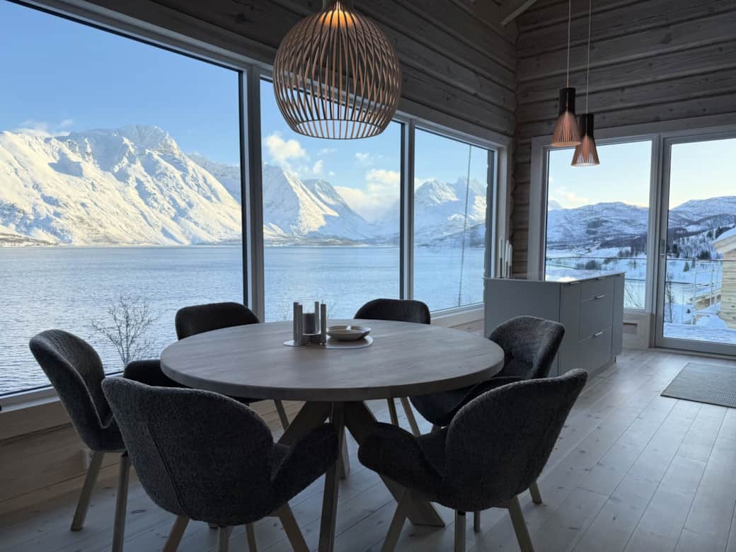 Modern kitchen with round dining table and fjord view – holiday home Nordlys