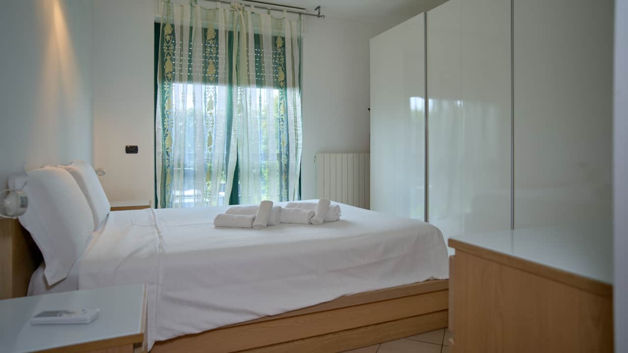 Double bedroom with built-in wardrobe and curtained window