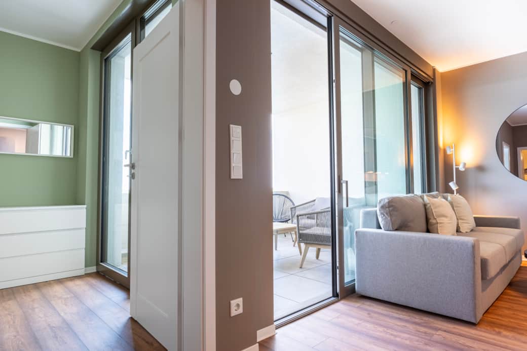 Hafen 6 Ap. 2, Wohnbereich, Blick ins Schlafzimmer und zum Balkon