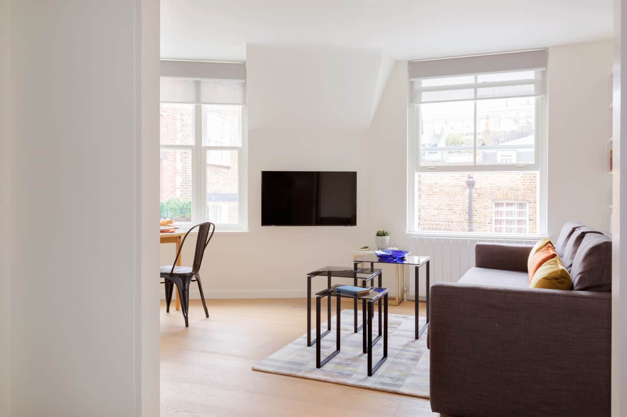 Bright loft-style living room with vaulted ceiling and dual sash windows