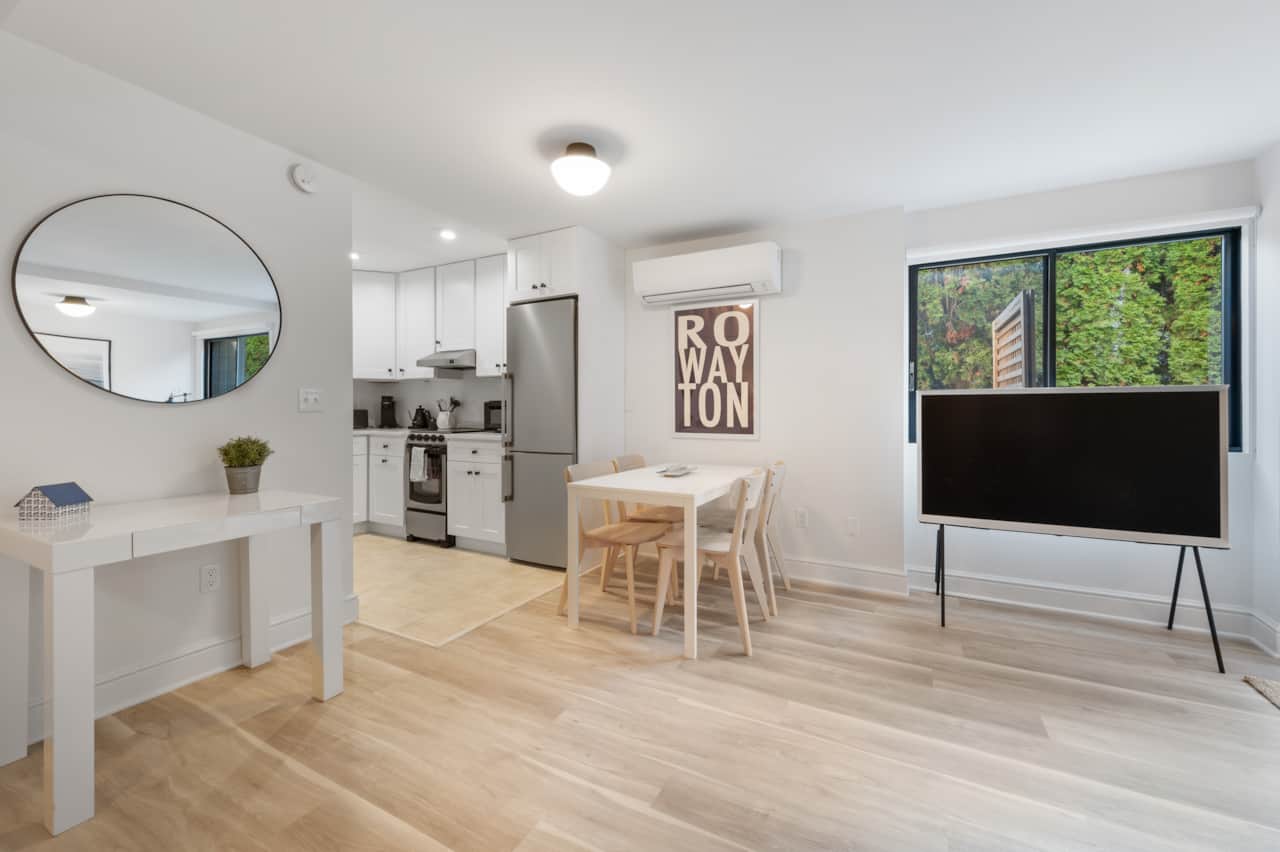 Living area with a large TV, comfy sofa, chair and walks out to a small private deck
