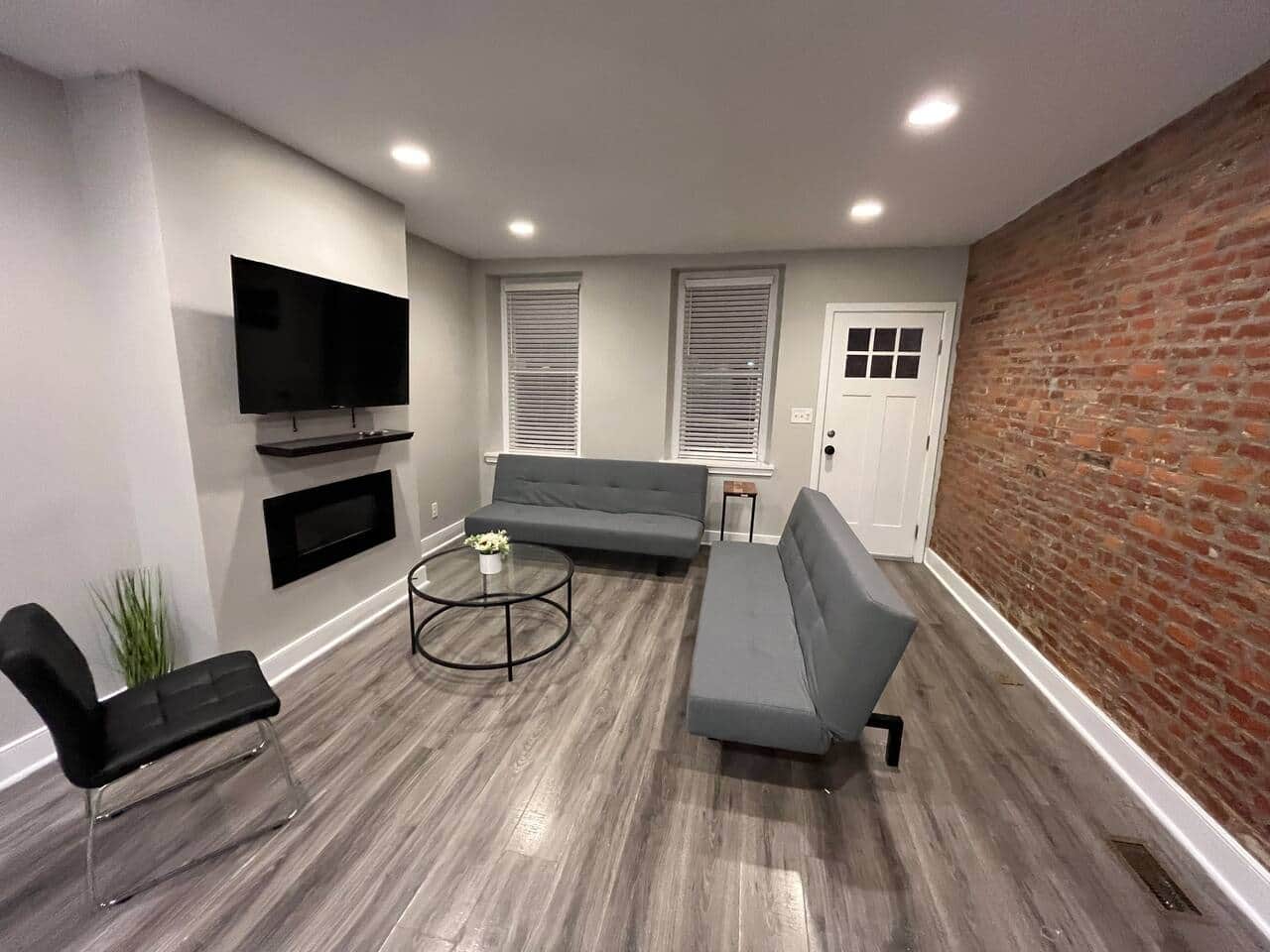 A generously sized living room boasting two comfortable Futon beds, a large flatscreen TV with an array of Ruko channels, and an elegant fireplace.