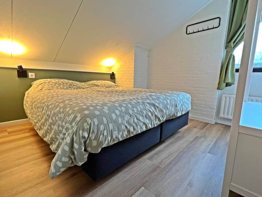 Hoofdslaapkamer met twee comfortabele eenpersoons boxspringbedden en een open kledingkast. In de kast hangen kledinghangers Hoofdslaapkamer met twee comfortabele eenpersoons boxspringbedden en een open kledingkast. In de kast hangen kledinghangers