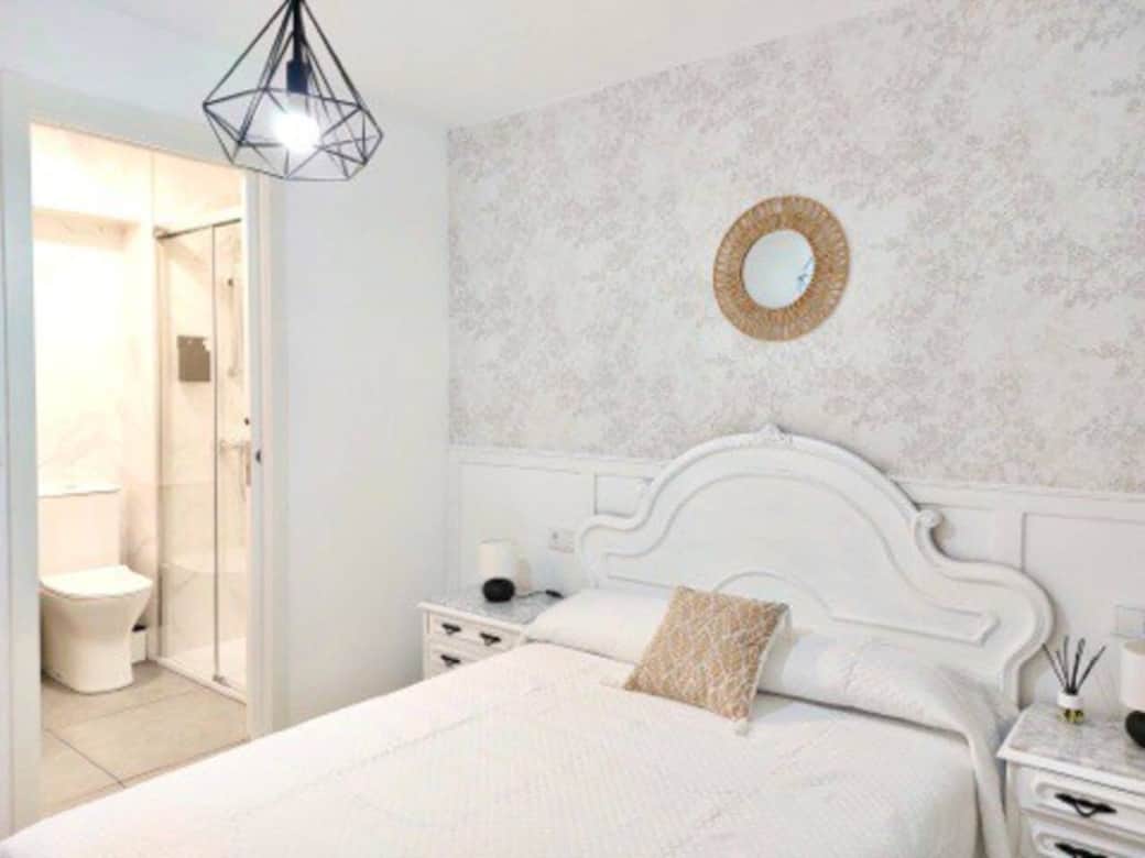 Habitación principal con cama de matrimonio y baño privado.