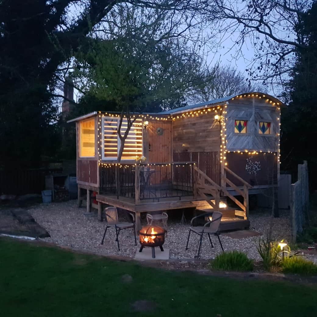 Evening fairy lights decorate the exterior of The Cosy Nest glamping pods. 