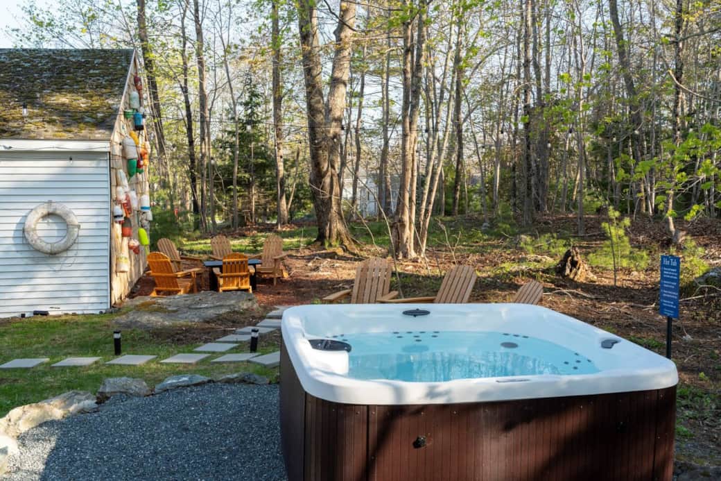 Our beautiful and year round outdoor area surrounded by the trees. Enjoy the hot tub, lawn games, & propane fire pit!