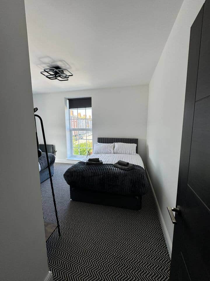 bedroom with double bed, smart tv and clothes rack