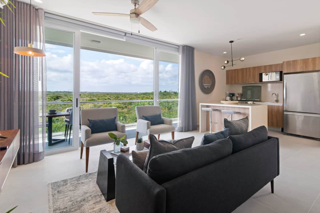 Bright living room with Smart TV, AC, balcony, and jungle views.