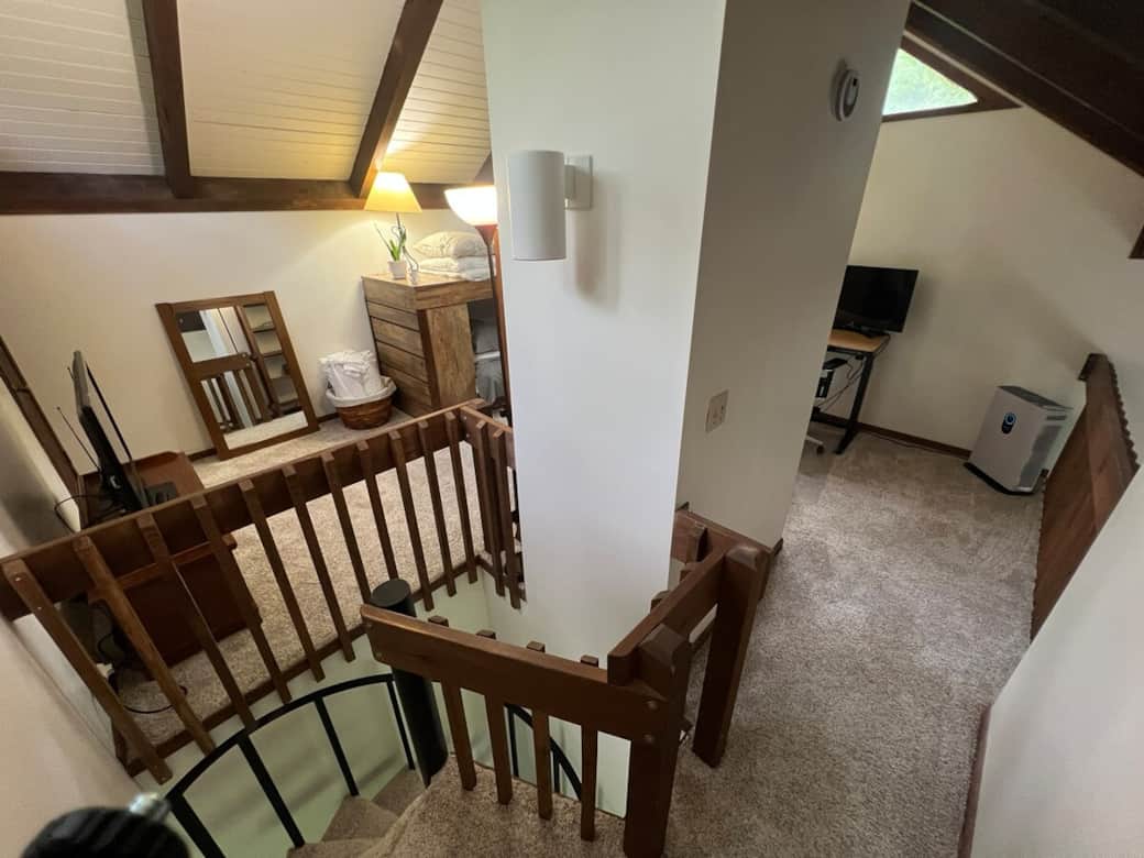 Loft with twin bunk beds, TV, games, and electric standing work station
