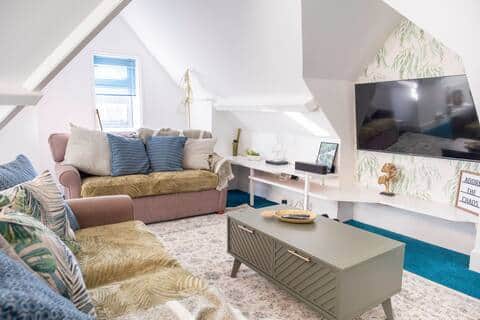 Bright, stylish loft living area with comfortable sofas, Smart TV, and coffee table Bright, stylish loft living area with comfortable sofas, Smart TV, and coffee table