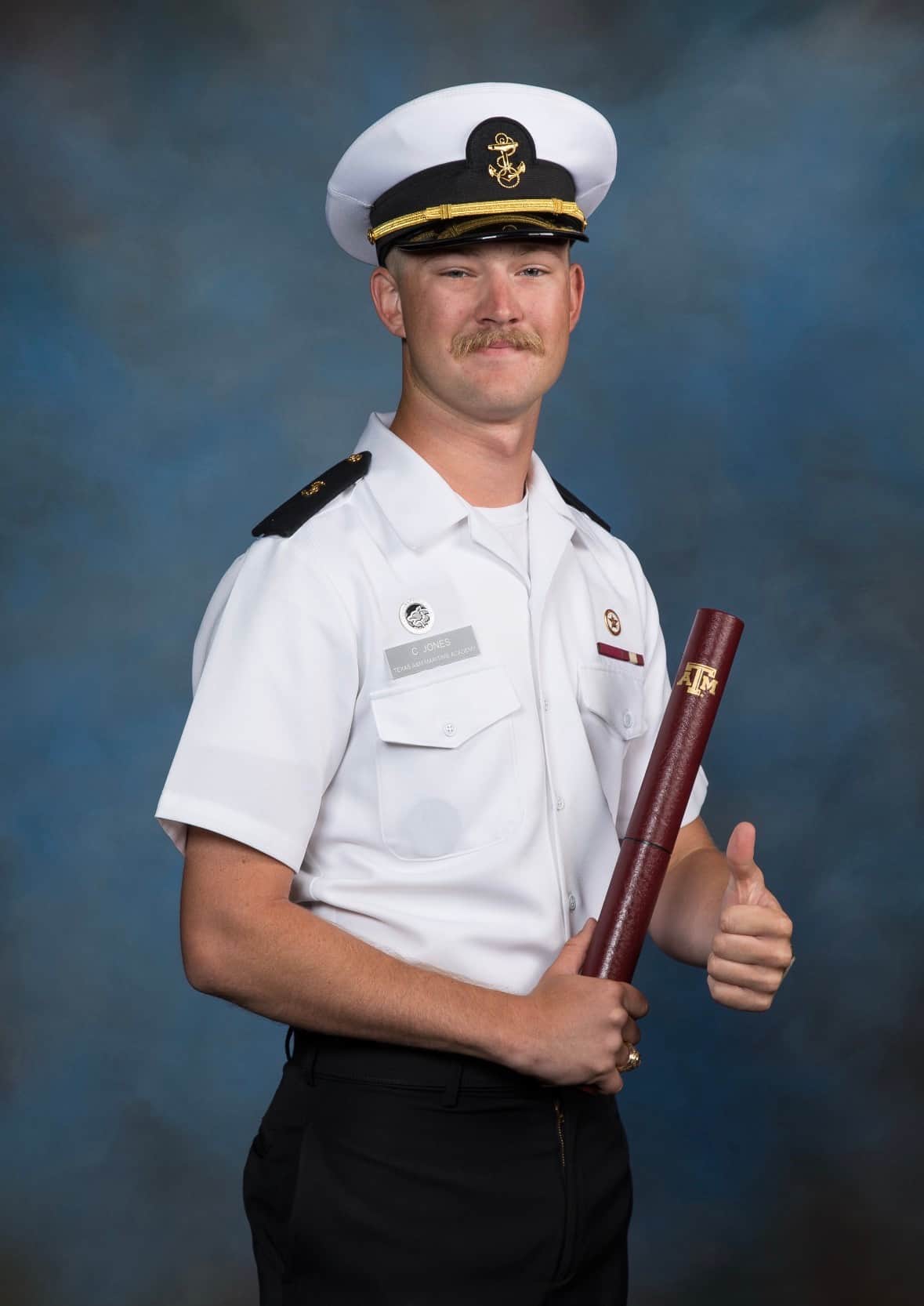 Texas A&M Galveston graduate celebrating outside campus sign