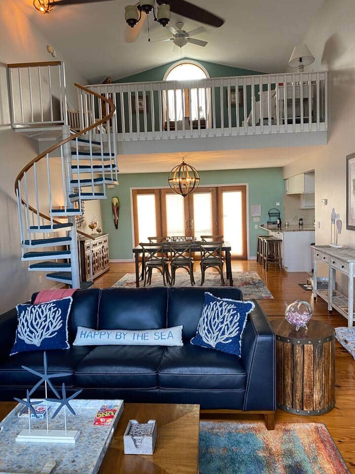 Living room with leather furniture, you can see the spiral staircase that leads to the loft.