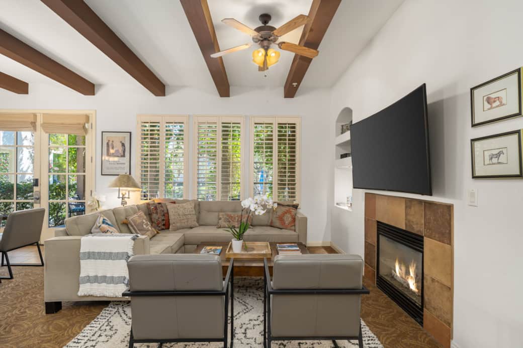 Cozy & stylish living room with a sectional, modern chairs, gas fireplace and a large flat-screen tv