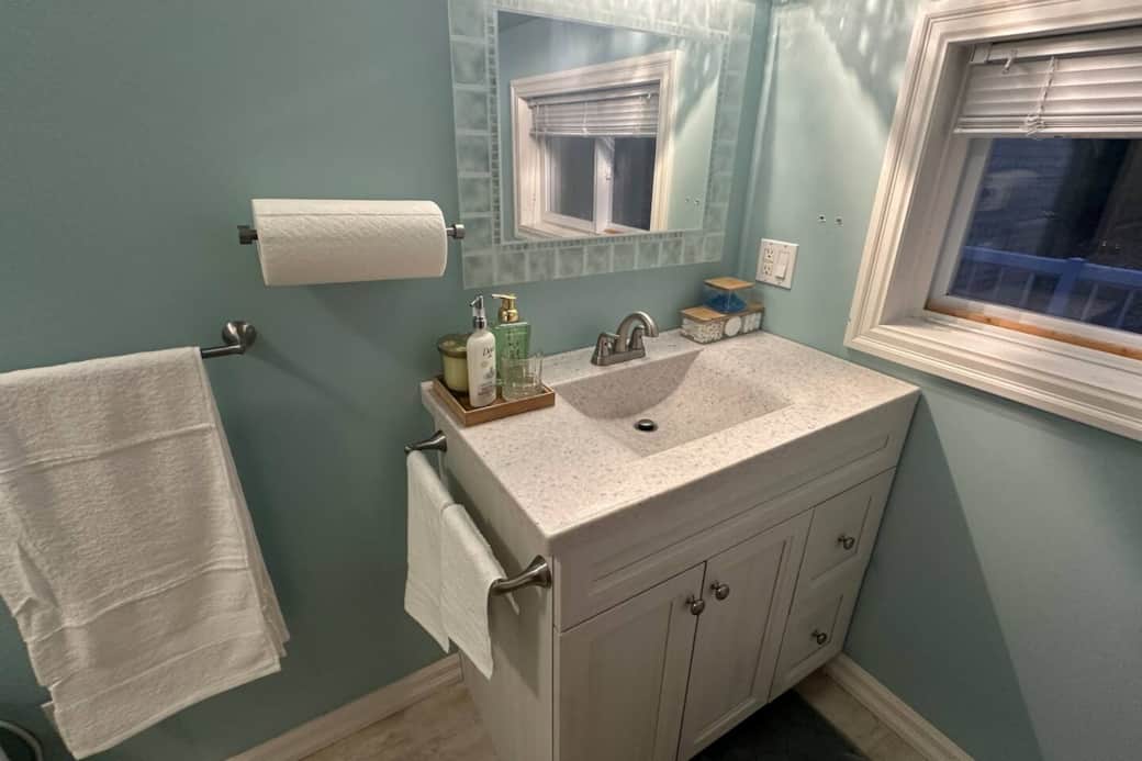 Clean and well-stocked bathroom featuring soft towels, essential toiletries, and a modern vanity.