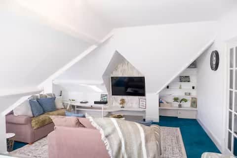 Bright, stylish loft living area with comfortable sofas, Smart TV, and coffee table Bright, stylish loft living area with comfortable sofas, Smart TV, and coffee table