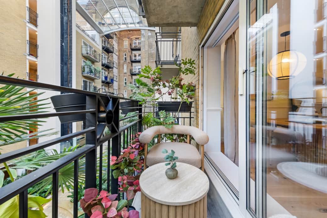 Charming balcony with seating, greenery and peaceful courtyard outlook Charming balcony with seating, greenery and peaceful courtyard outlook