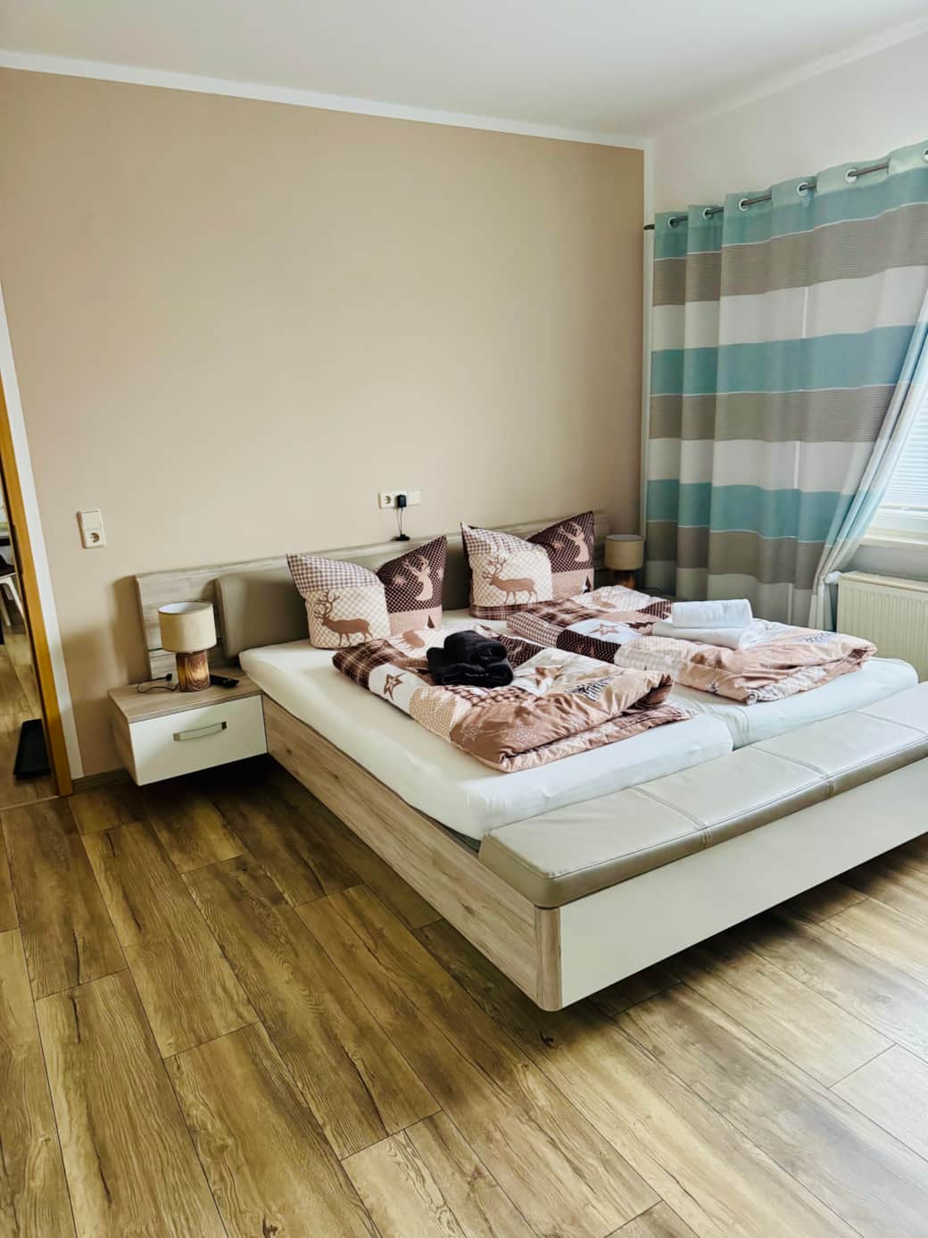 Schlafzimmer mit Doppelbett und zwei Einzelbetten