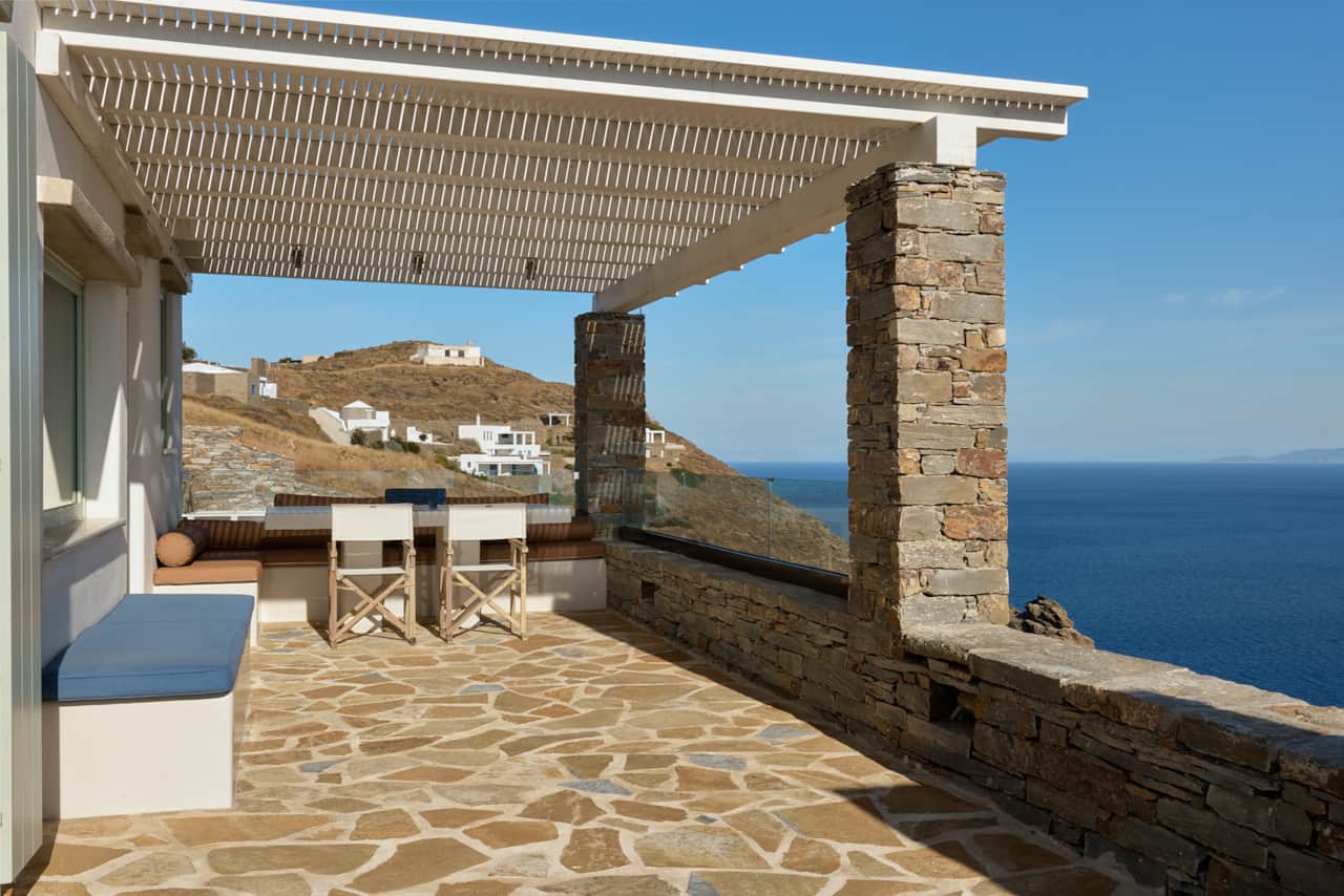 Shaded outdoor dining terrace overlooking the Aegean Sea