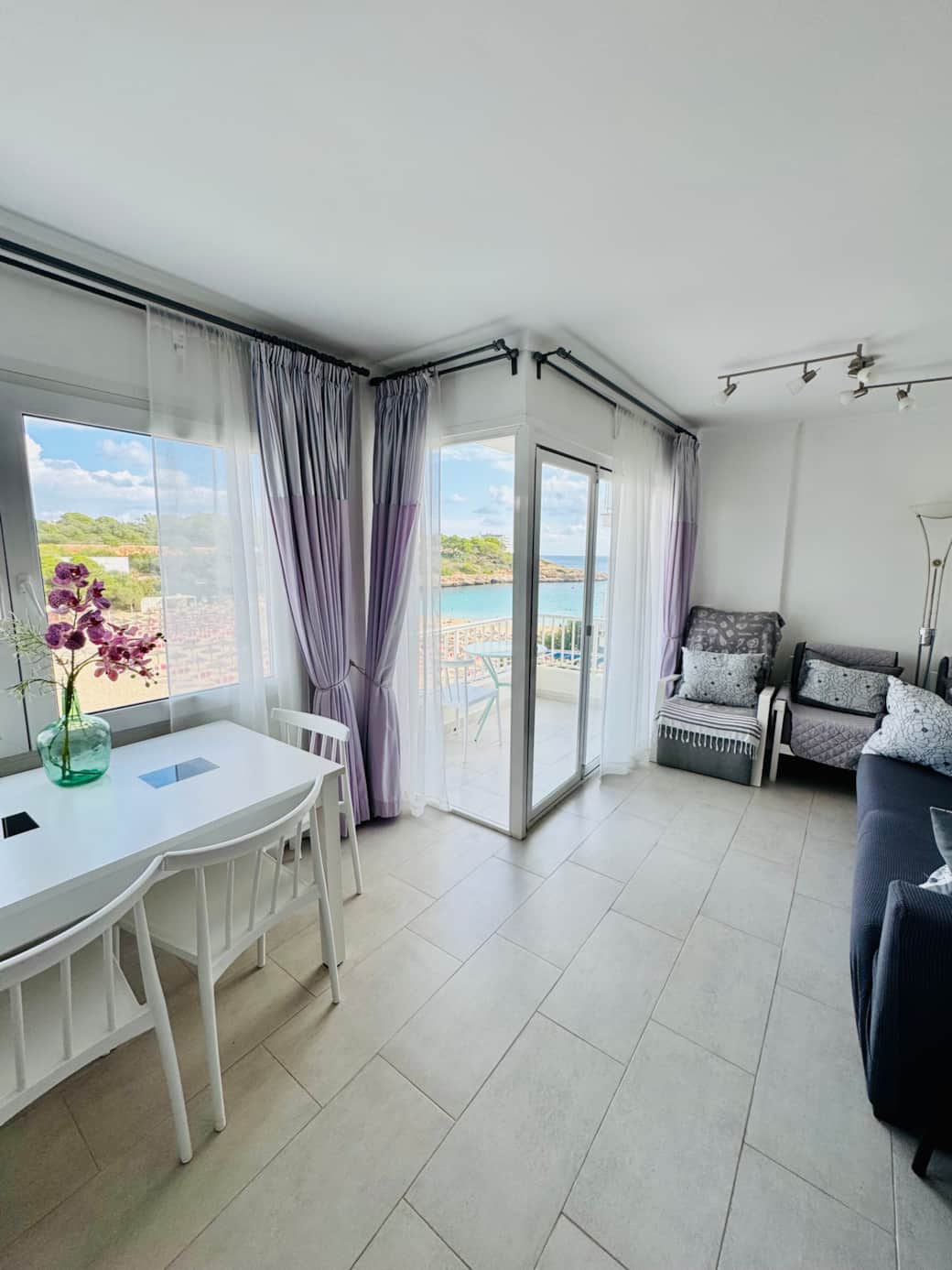 Bright, sun-filled living space with large windows framing the Mediterranean Sea Bright, sun-filled living space with large windows framing the Mediterranean Sea