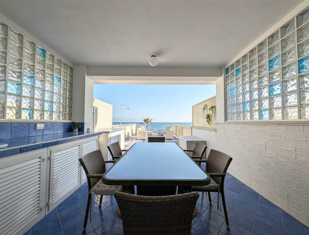 Covered terrace dining table facing the sea