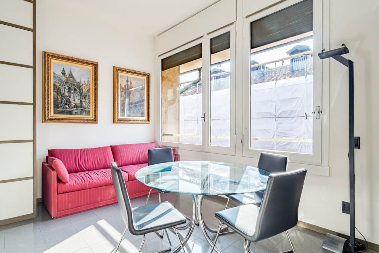 Living room with red sofa and glass table, in Brera, Milan