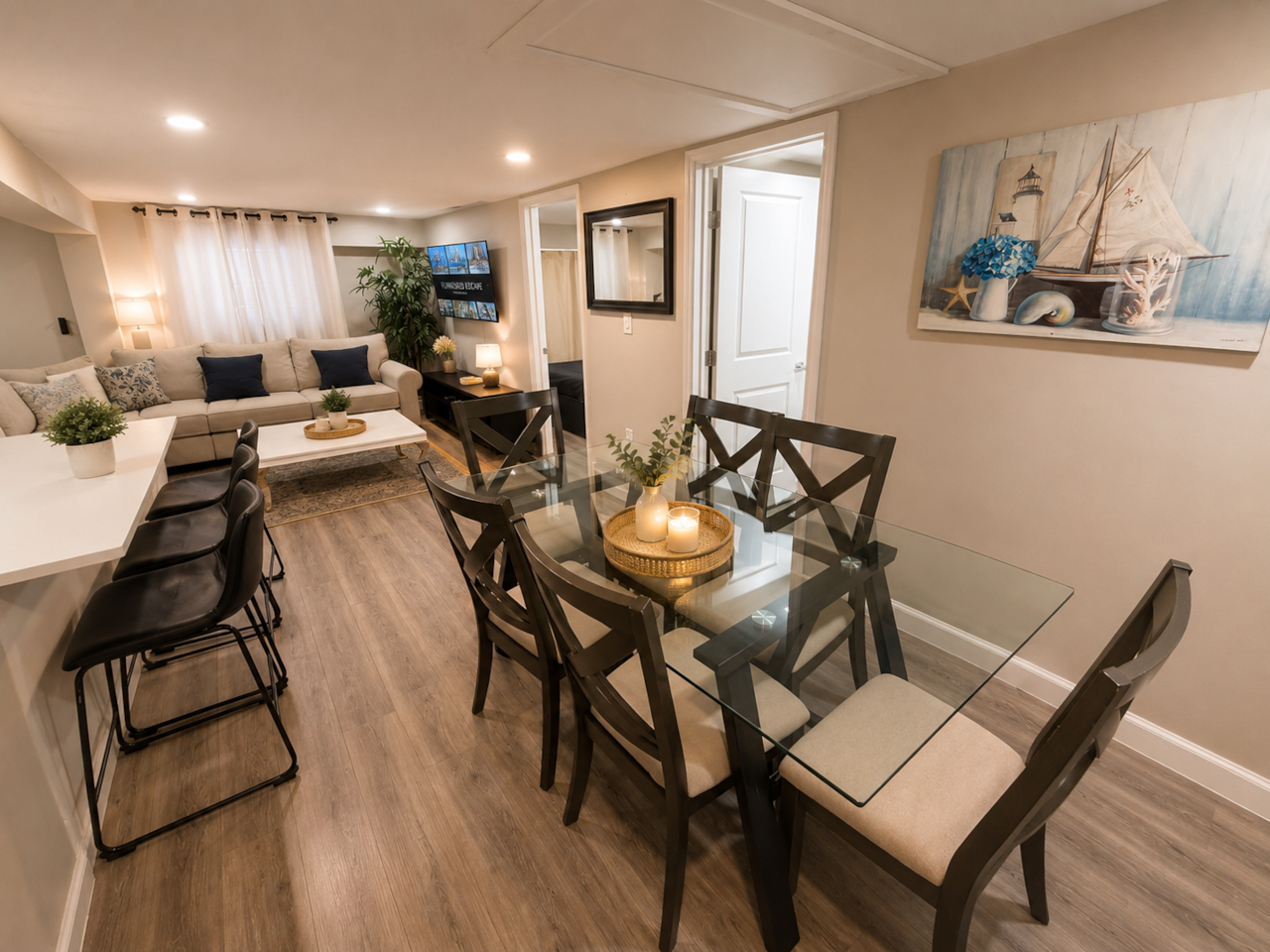 Spacious dining area featuring a large glass dining table with comfortable seating, seamlessly connected to the kitchen. The kitchen includes a beautiful quartz island countertop with barstool seating, creating the perfect open space for dining, entertaining, and spending time together.