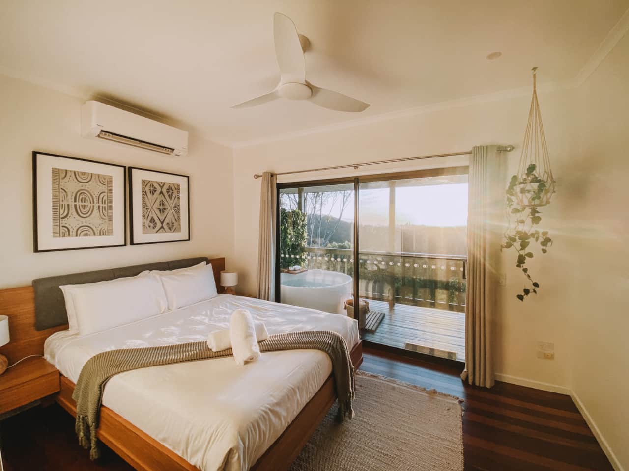 Comfortable queen bedroom — air-conditioning, ceiling fan, and a balcony with open-air bathtub.