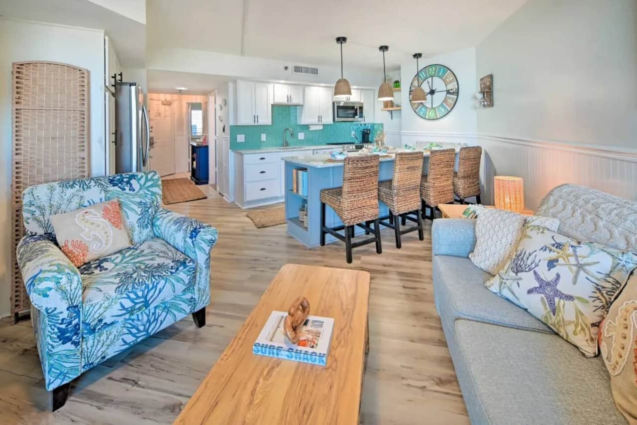 Stylish open-concept living room with designer coastal décor and modern furnishings.