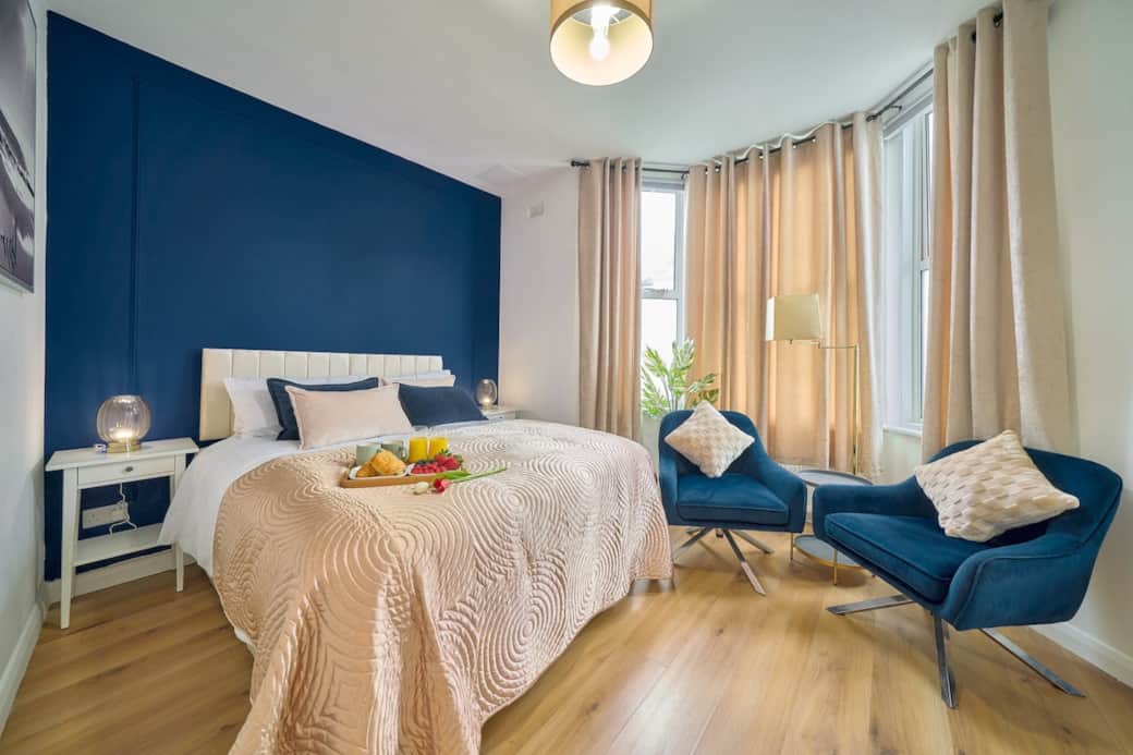Stylish bedroom with king-size bed and cosy seating area, The bed can be configured as either a king-size or two single beds, offering flexibility and comfort to suit each guest’s preference.