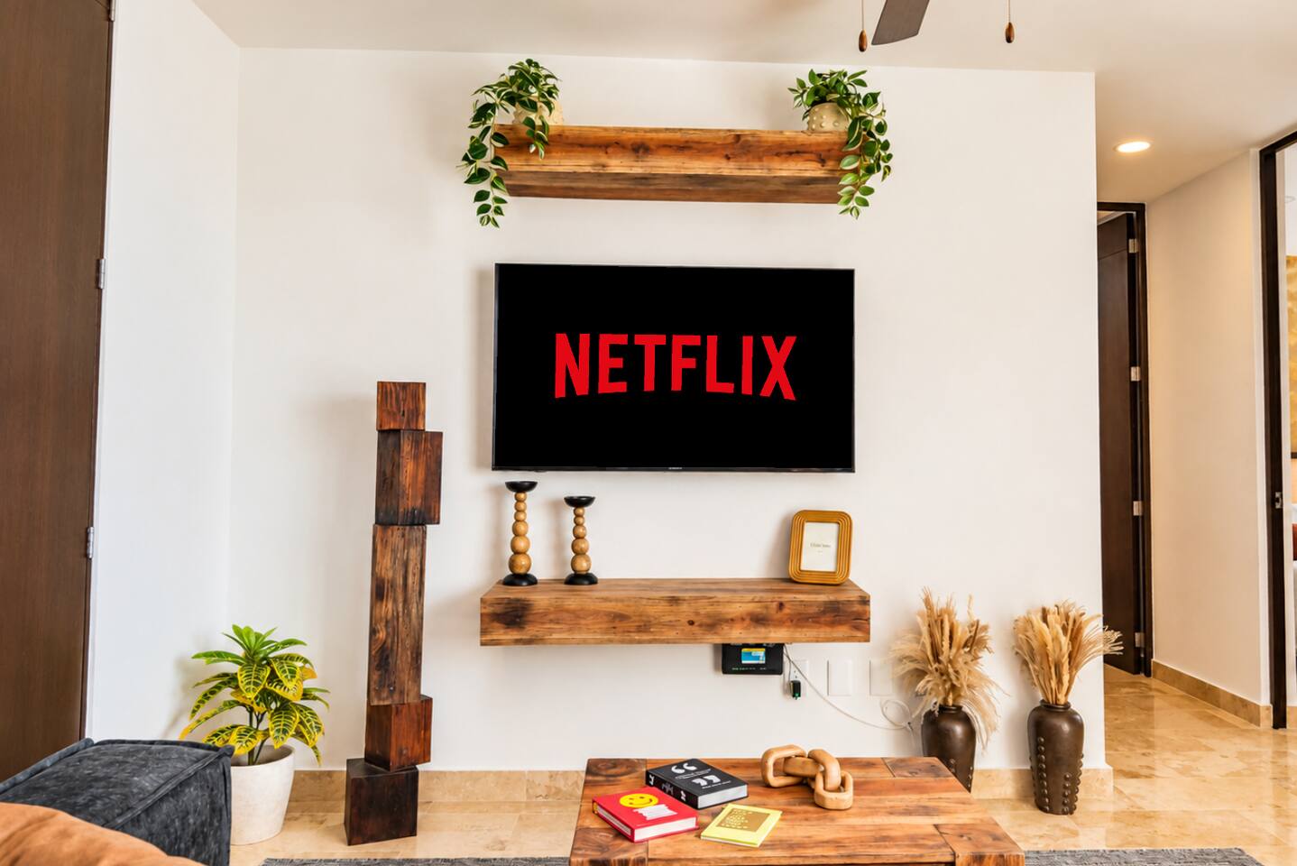Esta sala con aire acondicionado no solo cuenta con un cómodo sofá seccional, ventilador de techo y acceso directo a tu terraza privada y alberca con vista a la exuberante selva de Tulum; también incluye Smart TV y libros para disfrutar durante tu estancia.