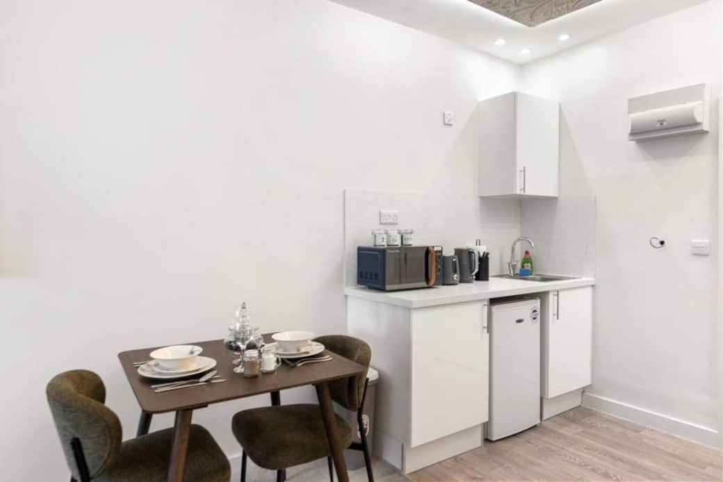 A cosy, modern dining area featuring a stylish table set for two, perfect for relaxed meals. A cosy, modern dining area featuring a stylish table set for two, perfect for relaxed meals.