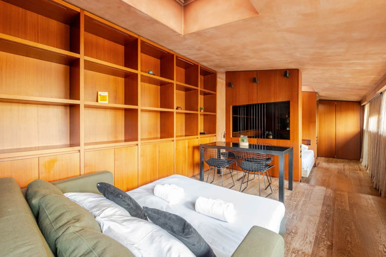 Zona de estar con cama y librería de pared, en Brera, Milán
