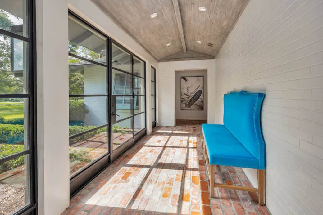 The sun-drenched foyer has brick floors and pecky cypress ceilings. 