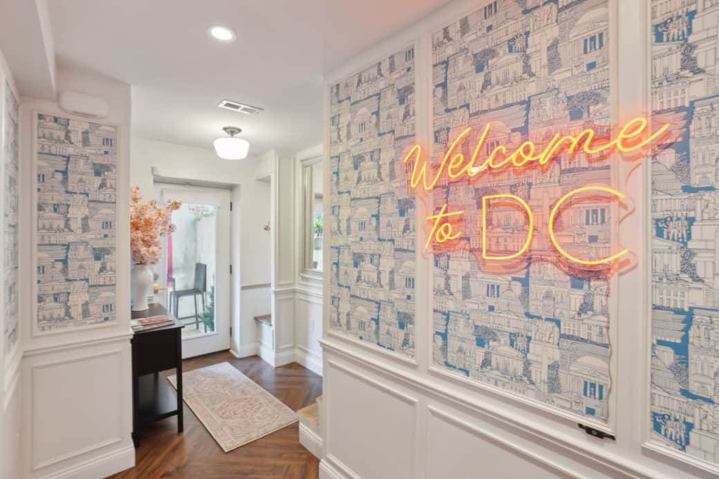 Signature hallway with DC map wallpaper and custom neon welcome sign