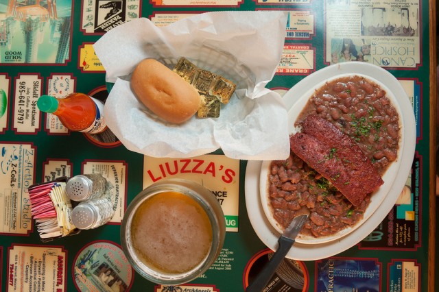 a table with a plate of beans and bread and a cup of soup