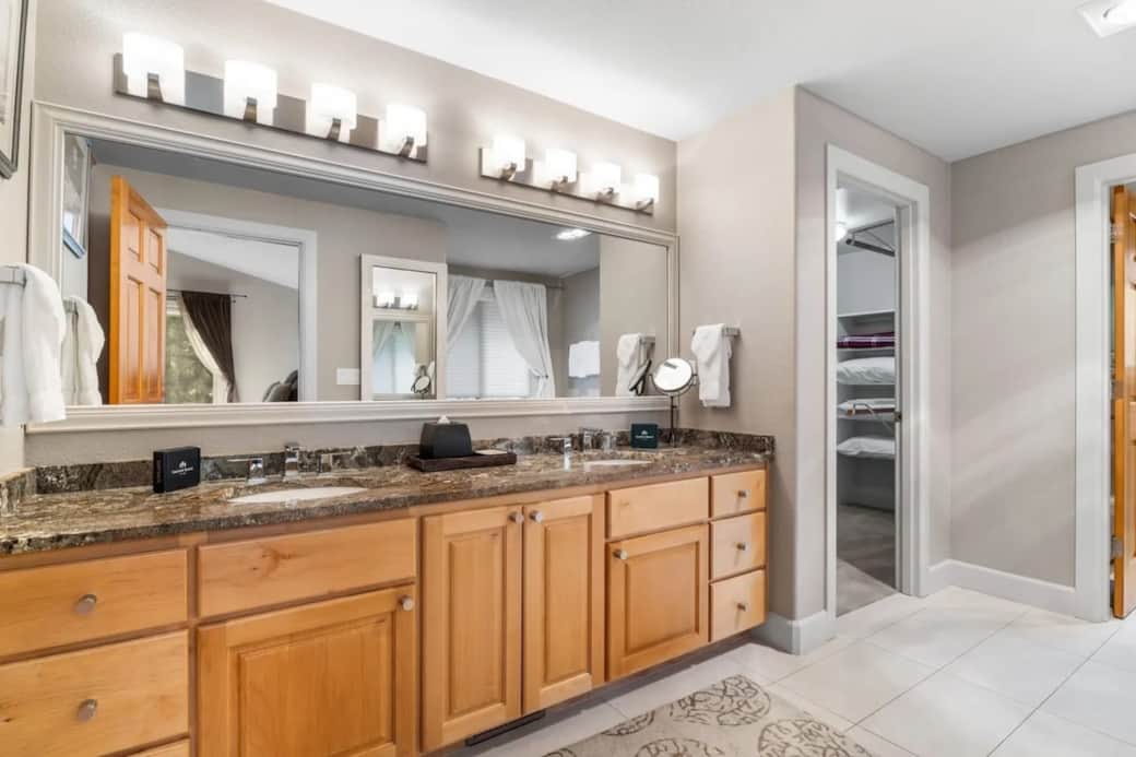 Primary main level bathroom with dual vanity and large walk-in closet