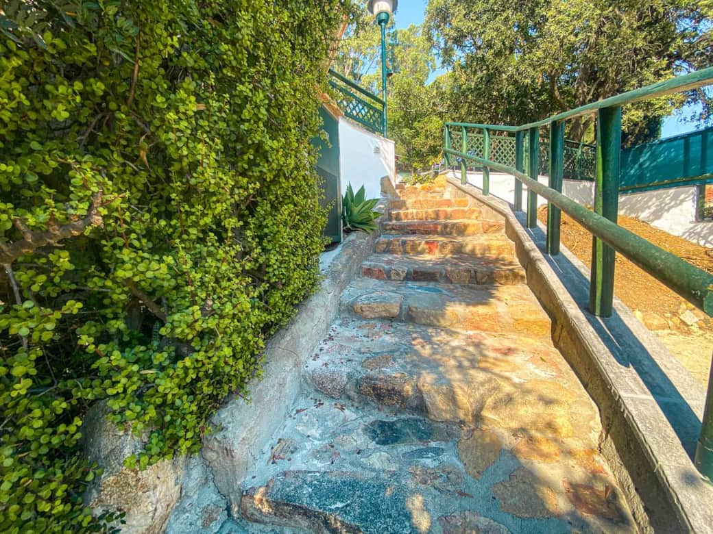Accesso alla villetta tramite scalinata privata in pietra, con vegetazione laterale e corrimano. Un passaggio curato che accompagna l’ingresso nella zona abitativa.