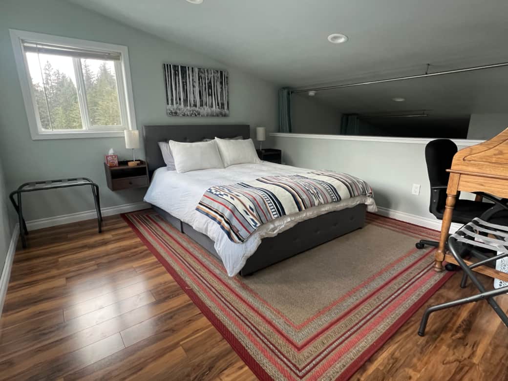 This cozy loft hideaway offers plush bedding, natural light and peaceful treetop and lake views