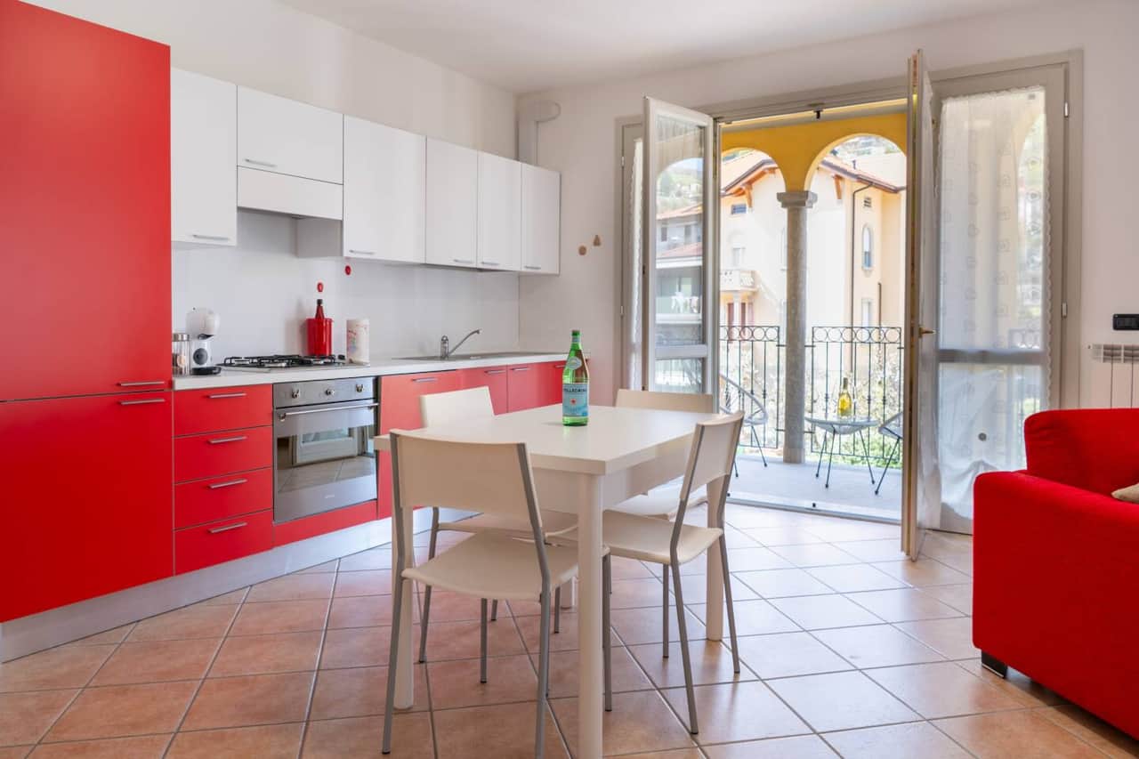Ampio ed accogliente soggiorno con divano letto, smart TV, cucina open space e accesso diretto al balcone