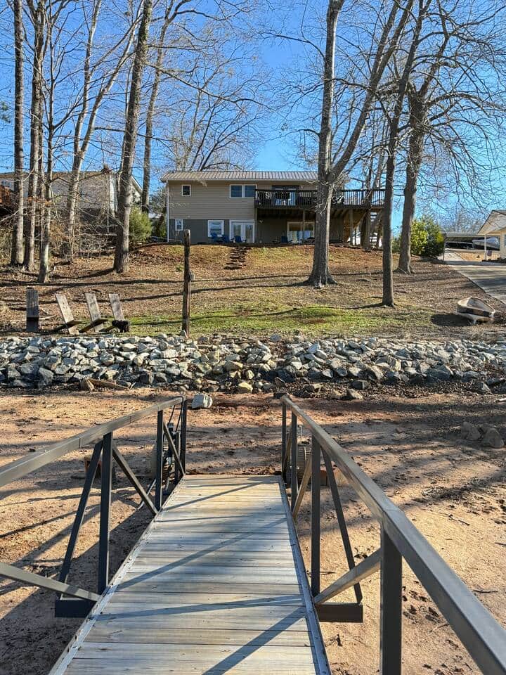View of the house from the dock. The boat launch is a solid path down to the lake.