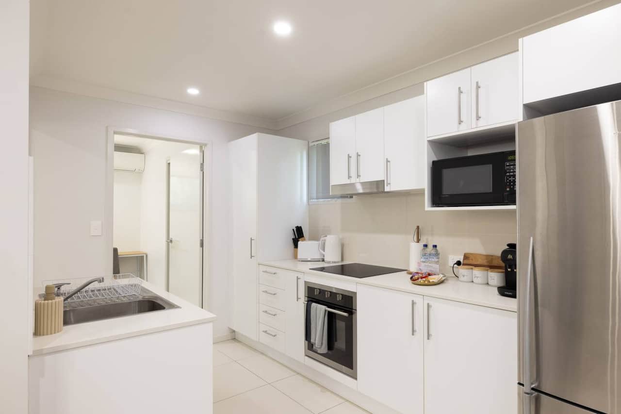 Kitchen: Sleek kitchen with ample storage, modern appliances 