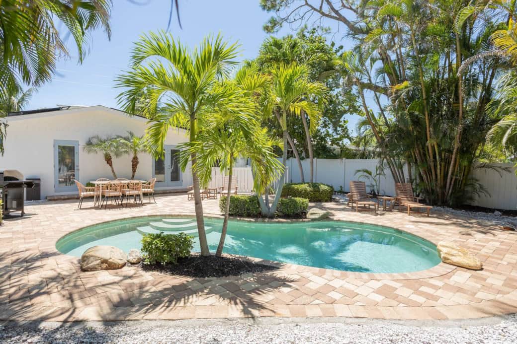 Private custom heated pool at the AMI villa—palms, loungers, and beach steps away.