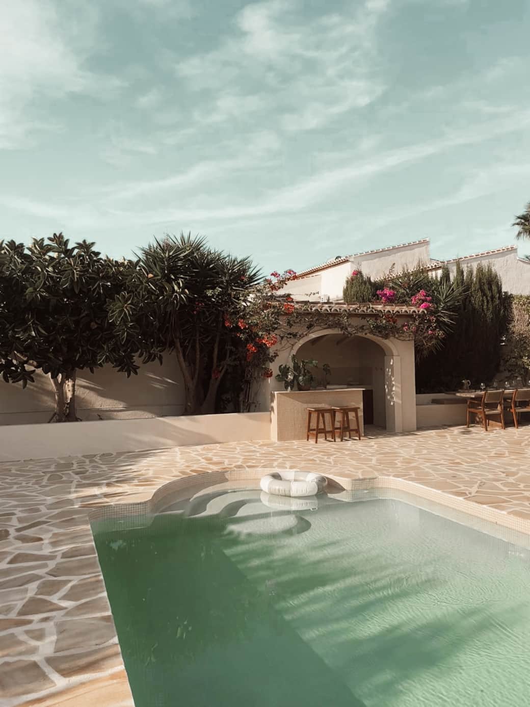 De buitenkeuken met BBQ, koelkast en gezellige bar.