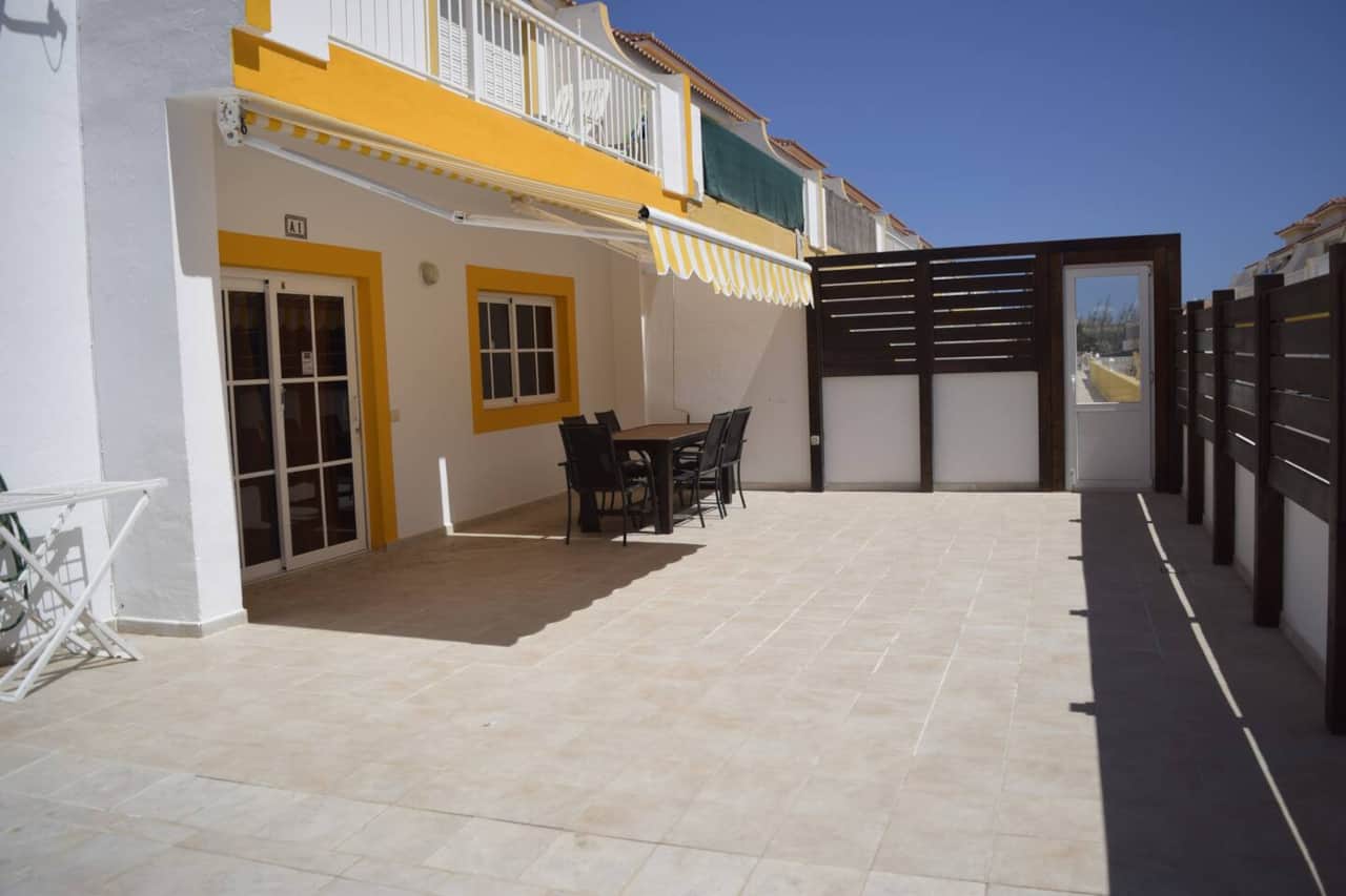 Fachada y terraza con mesa y sillas