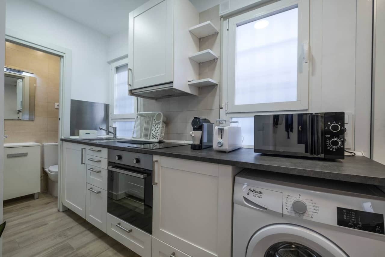 Cocina equipada con horno, vitrocerámica, cafetera y lavadora