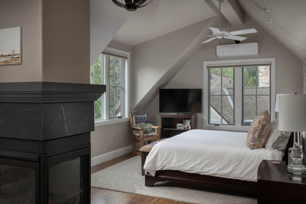 The comfortable primary bedroom features a king bed, gas fireplace, A/C and mountain views