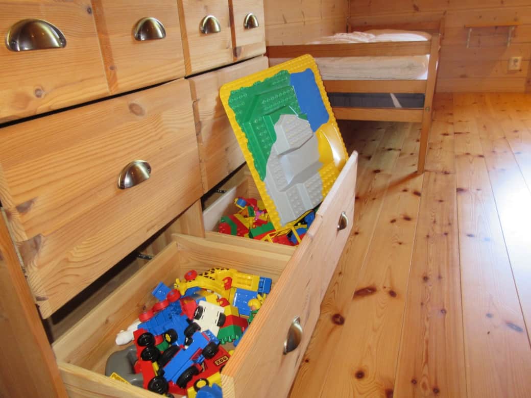 Zusätzlich steht in diesem Raum eine Kommode zur Verfügung, die sowohl Stauraum für Kleidung bietet als auch eine größere Menge Duplosteine bereithält, mit denen Ihre Kinder spielen können.