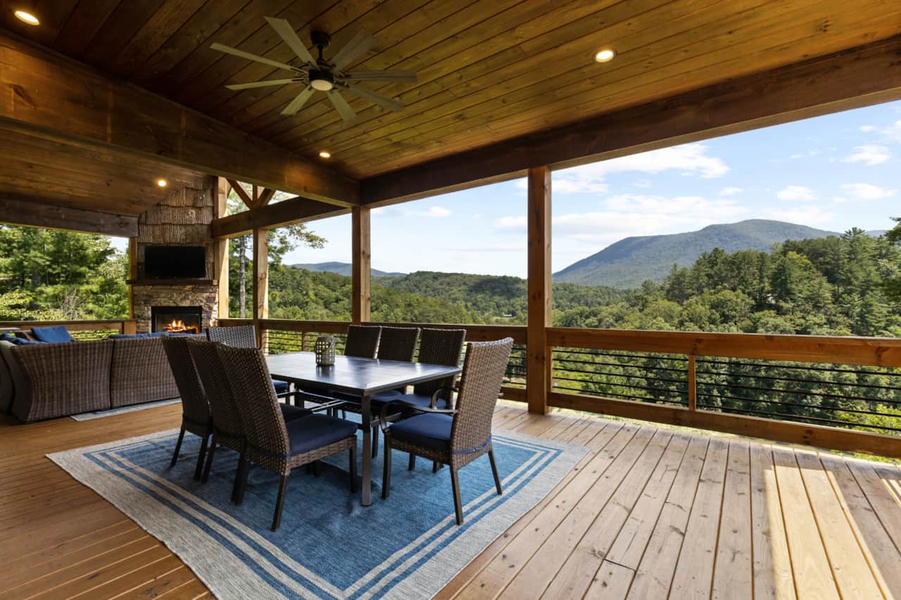 Covered deck with outdoor dining, fireplace and mountain views