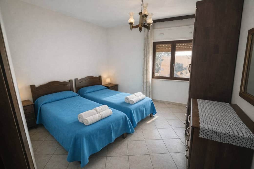 Camera spaziosa con due letti singoli, perfetta per amici o famiglia, con luce naturale e arredi classici in legno. Camera spaziosa con due letti singoli, perfetta per amici o famiglia, con luce naturale e arredi classici in legno.
