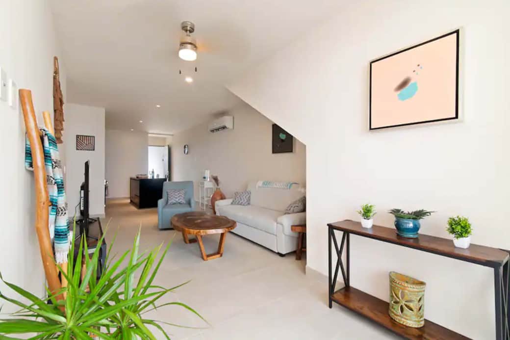 Stylish living room: Art, AC, ceiling fan, versatile couch-bed. Perfect retreat for relaxation.